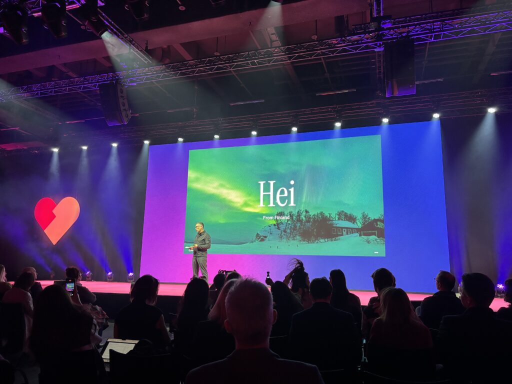Main-stage presentation at health.tech global summit 2026 in Basel with an audience and a large screen showing “Hei — From Finland.”